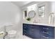 A well-lit bathroom featuring a blue vanity with gold hardware and a round mirror at 2857 Linden Dr, Boulder, CO 80304