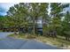 Modern home nestled among mature trees, featuring a paved driveway and steps leading to a deck at 2857 Linden Dr, Boulder, CO 80304