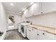 Well-organized laundry room with a washer, dryer, white cabinets, and a butcher block countertop at 2857 Linden Dr, Boulder, CO 80304