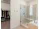 Contemporary bathroom showcasing a frameless glass shower, soaking tub, and walk-in closet entrance at 7404 Greenwater Cir, Castle Rock, CO 80108