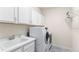 Laundry room equipped with new washer and dryer, sink, and ample cabinet storage at 7404 Greenwater Cir, Castle Rock, CO 80108
