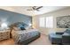 Comfortable main bedroom featuring a ceiling fan, shutters, and a calming blue accent wall at 7404 Greenwater Cir, Castle Rock, CO 80108