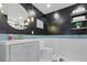 Stylish bathroom featuring modern vanity with blue tile accent, round mirror, and unique lighting at 3425 W 111Th Loop # B, Westminster, CO 80031