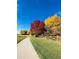 Picturesque walking path bordered by lush green grass and trees with vibrant fall colors at 3425 W 111Th Loop # B, Westminster, CO 80031