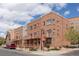 Attractive multi-story brick townhomes with balconies and well-kept landscaping on a tree-lined street at 7883 W 55Th Ave, Arvada, CO 80002