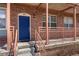 Charming brick townhome front entrance featuring blue door and cozy porch area at 7883 W 55Th Ave, Arvada, CO 80002