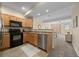 Traditional kitchen featuring wooden cabinets, black appliances, and a dining area at 7883 W 55Th Ave, Arvada, CO 80002