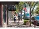 Charming street view with brick buildings, trees, American flags, and people walking at 7883 W 55Th Ave, Arvada, CO 80002