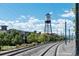 View of the Arvada water tower with lush greenery, railway tracks, and a bright blue sky at 7883 W 55Th Ave, Arvada, CO 80002