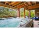 Backyard patio features a hot tub with wood beam pergola at 10305 Charissglen Cir, Highlands Ranch, CO 80126