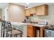 Basement bar area with wooden cabinets, seating, and a sink at 10305 Charissglen Cir, Highlands Ranch, CO 80126