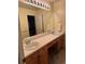 Bathroom boasting a double sink vanity, lots of storage, and large mirror at 10305 Charissglen Cir, Highlands Ranch, CO 80126