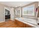 Bright bathroom featuring a soaking tub, glass shower, and wood look floors at 10305 Charissglen Cir, Highlands Ranch, CO 80126