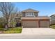 Charming two-story home featuring a brick facade and a three-car garage, complemented by a well-manicured lawn at 10305 Charissglen Cir, Highlands Ranch, CO 80126