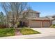 Charming two-story home featuring a brick facade and a three-car garage, complemented by a well-manicured lawn at 10305 Charissglen Cir, Highlands Ranch, CO 80126