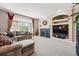 Cozy living room featuring a fireplace, plush seating, large window, and built-in shelving at 10305 Charissglen Cir, Highlands Ranch, CO 80126