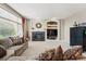 Comfortable living room with large window, fireplace, built-ins, and neutral carpeting at 10305 Charissglen Cir, Highlands Ranch, CO 80126