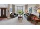 Cozy living room with large bay windows, comfortable seating, and neutral-toned carpeting at 10305 Charissglen Cir, Highlands Ranch, CO 80126