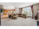Open concept living room with large windows and attached kitchen area at 10305 Charissglen Cir, Highlands Ranch, CO 80126