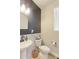 Stylish half-bathroom with wainscoting, vessel sink and window features modern fixtures and lighting at 5154 Bittercress Rd, Brighton, CO 80640