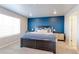 Charming bedroom with a blue accent wall and a comfortable queen-sized bed at 5154 Bittercress Rd, Brighton, CO 80640