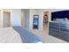 Comfortable bedroom with a full-length mirror, a large closet and a bed covered with a blue blanket at 5154 Bittercress Rd, Brighton, CO 80640