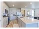 A modern kitchen features stainless steel appliances, a large island and sleek grey cabinets at 5154 Bittercress Rd, Brighton, CO 80640