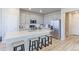 Open kitchen features gray cabinets, stainless appliances and large island with barstool seating at 5154 Bittercress Rd, Brighton, CO 80640