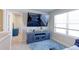 Cozy loft area featuring a blue media center, a television, and a bright window at 5154 Bittercress Rd, Brighton, CO 80640