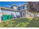 Backyard view showing a blue home exterior with grass, trash bins, and privacy fence at 1133 S Richfield St, Aurora, CO 80017