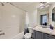 Bathroom with a bathtub-shower combination, toilet, and sink with a mirror at 1133 S Richfield St, Aurora, CO 80017