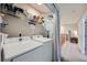Laundry room featuring two white Samsung machines and shelving, located next to the hallway at 1133 S Richfield St, Aurora, CO 80017