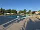 Community swimming pool area with lounge chairs and trees on a sunny day at 1133 S Richfield St, Aurora, CO 80017