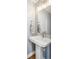 Elegant powder room featuring a pedestal sink, modern faucet, and decorative hand towel at 2801 Cherry St, Denver, CO 80207