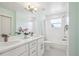 Bright bathroom features double sink vanity, large mirror, and shower-tub combo at 2801 Cherry St, Denver, CO 80207