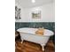 Beautiful soaking tub with rustic wood floors and teal tiled wall at 2801 Cherry St, Denver, CO 80207
