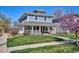 Attractive two-story home with a well-manicured lawn, a front porch, and a vibrant tree, enhancing curb appeal at 2801 Cherry St, Denver, CO 80207