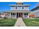 Charming two-story home featuring a welcoming front porch, lush green lawn, and vibrant landscaping for curb appeal at 2801 Cherry St, Denver, CO 80207