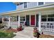 Cozy front porch featuring a red door, potted plants, and comfortable seating, creating a welcoming entrance at 2801 Cherry St, Denver, CO 80207