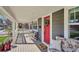 Inviting front porch with comfortable seating, a vibrant red door, and charming decor at 2801 Cherry St, Denver, CO 80207