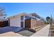 Detached garage with a white door and modern design, complemented by a fenced yard and street view at 2801 Cherry St, Denver, CO 80207