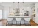 Bright kitchen with stainless appliances, white cabinets, and a large island with seating at 2801 Cherry St, Denver, CO 80207