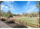 Scenic backyard view with lush greenery, a wooden fence, and a peaceful walking path at 23965 E Kettle Pl, Aurora, CO 80016