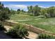 Scenic backyard view with a path through a lush green and natural space at 23965 E Kettle Pl, Aurora, CO 80016