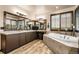 Luxurious bathroom with a soaking tub, double vanity, and wood-look floors, creating a spa-like retreat at 23965 E Kettle Pl, Aurora, CO 80016