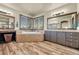 Bright bathroom featuring a soaking tub, wooden cabinets, and a double vanity underneath a large mirror and bright lighting at 23965 E Kettle Pl, Aurora, CO 80016