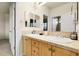 Bright bathroom featuring a double sink vanity with tile countertops and a framed mirror at 23965 E Kettle Pl, Aurora, CO 80016