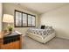 Cozy bedroom with a patterned bedspread, plush carpet, and dark framed windows at 23965 E Kettle Pl, Aurora, CO 80016
