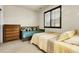 Bright bedroom featuring a twin bed, twin daybed, neutral carpet, and dark framed windows at 23965 E Kettle Pl, Aurora, CO 80016