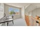 Hallway overlooking the staircase landing with a desk and monitor, lit by a window, and a chandelier at 23965 E Kettle Pl, Aurora, CO 80016
